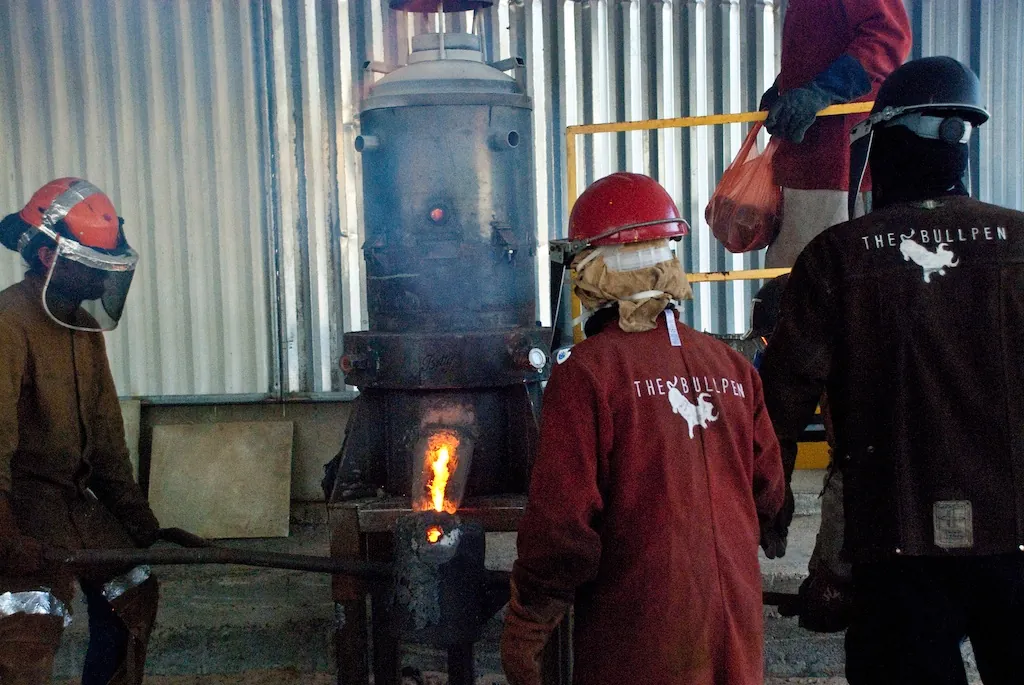 Molten iron running from the furnace spout into a ladle